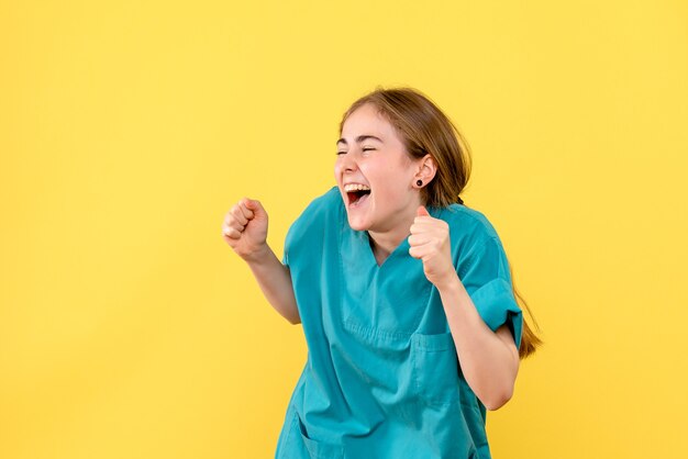 Front view female doctor happily excited on yellow background emotion hospital medic health