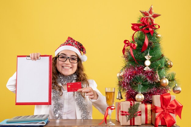 Front view female doctor holding bank card and file note