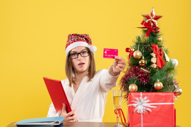 Front view female doctor holding bank card and file note