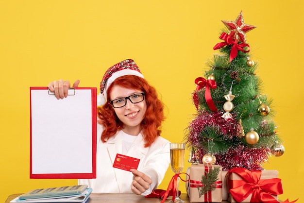 Front view female doctor holding bank card and note