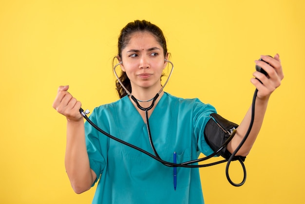 Front view female doctor holding blood pressure measuring device