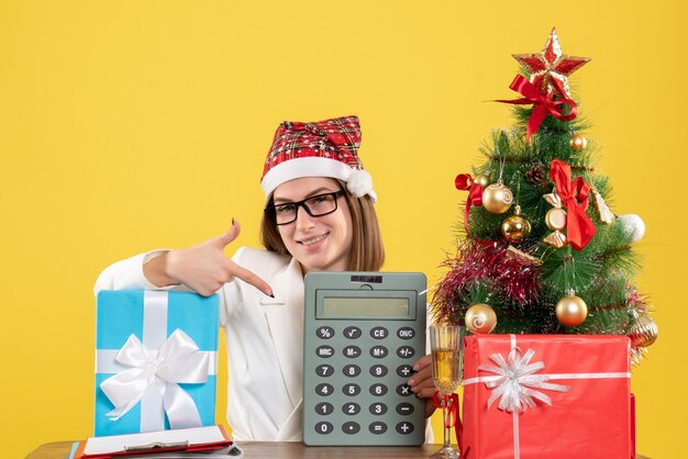 Front view female doctor holding calculator