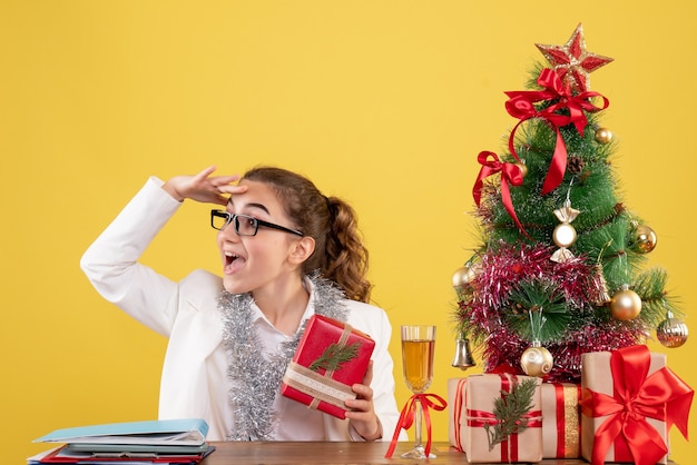 Front view female doctor holding christmas present