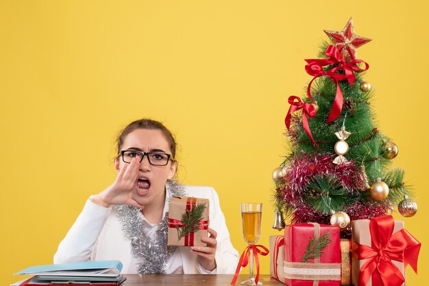 Front view female doctor holding christmas present