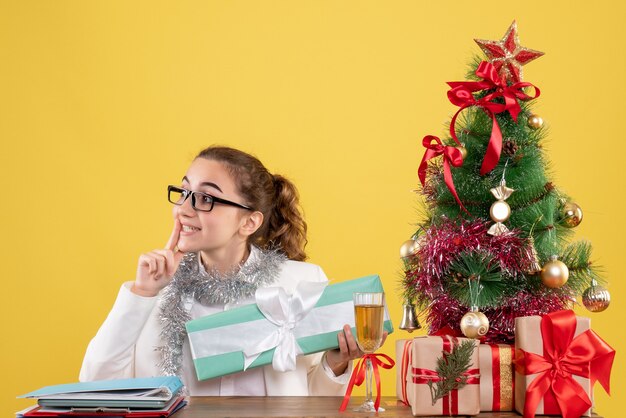 Front view female doctor holding christmas present