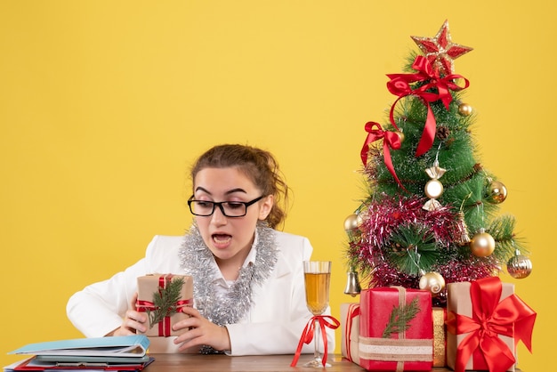 Front view female doctor holding christmas present