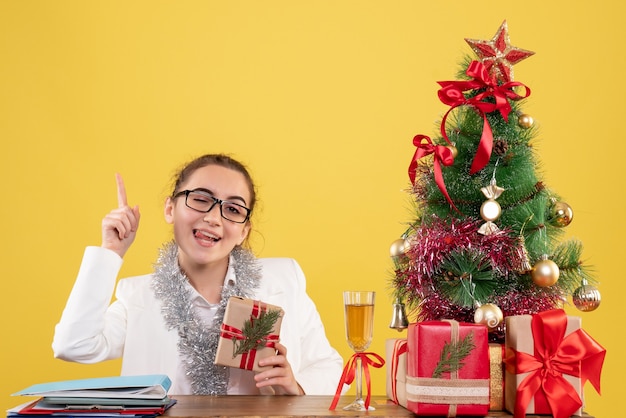 Front view female doctor holding christmas present