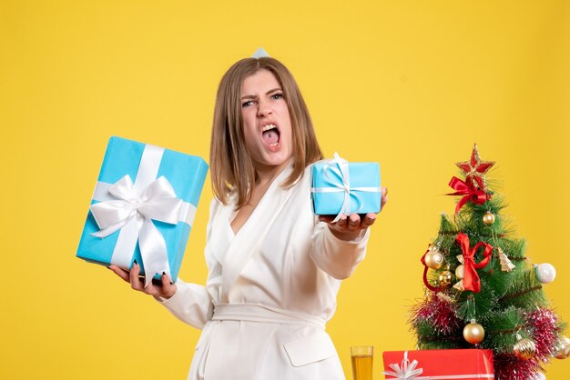Front view female doctor holding christmas presents