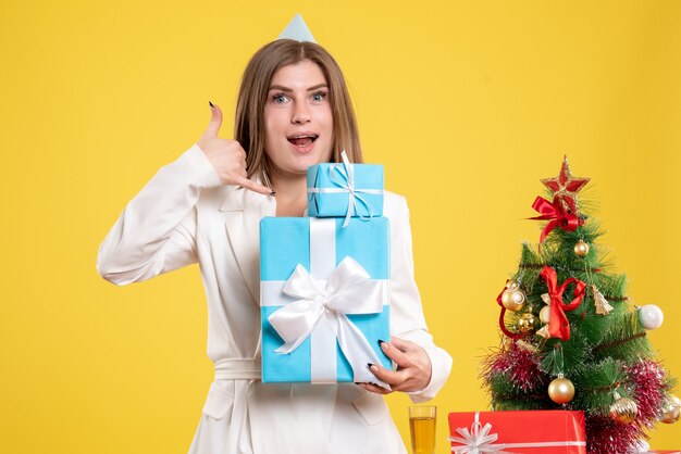 Front view female doctor holding christmas presents