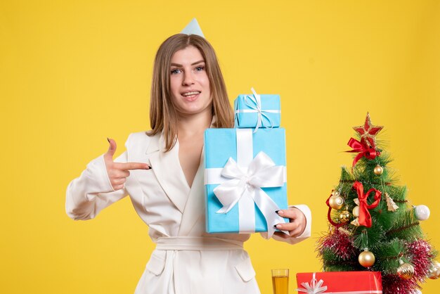 Вид спереди женщина-врач, держащая рождественские подарки