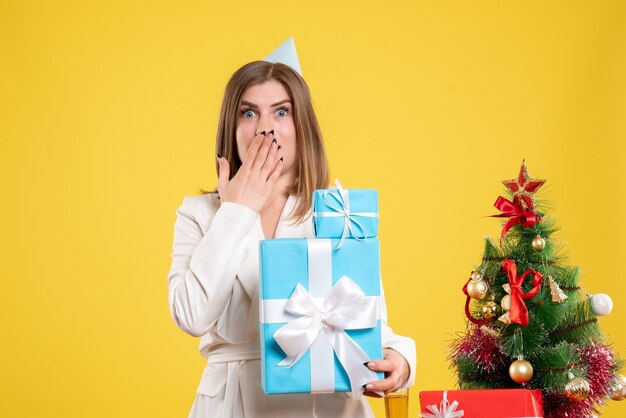 Front view female doctor holding christmas presents