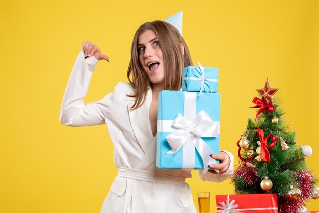 Front view female doctor holding christmas presents