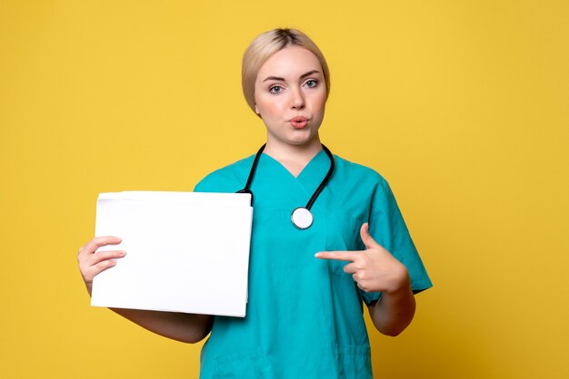 Front view female doctor holding different papers, pandemic health medic covid-19 nurse virus