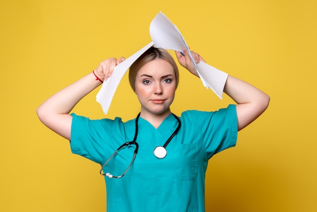 Front view female doctor holding different papers, pandemic health medic hospital virus nurse covid