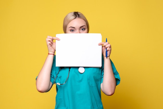 Front view female doctor holding different papers, virus pandemic health medic nurse covid-19 hospital