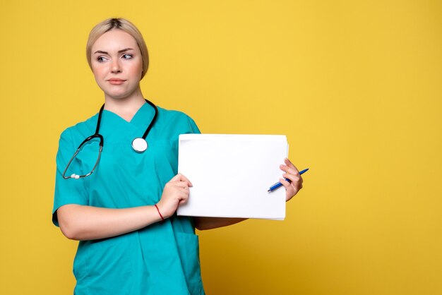 노란색 책상 바이러스 전염병 건강 의료진 간호사 COVID-19 병원에 다른 서류를 들고 전면보기 여성 의사