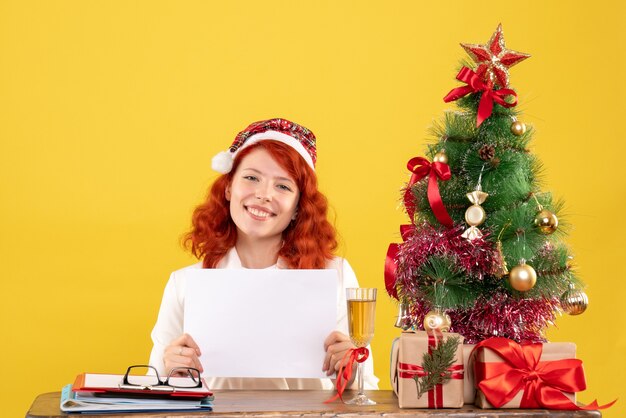 Front view female doctor holding documents behind table with presents