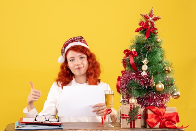 Front view female doctor holding documents behind table with presents