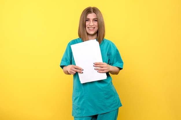 Front view female doctor holding documents on a yellow space