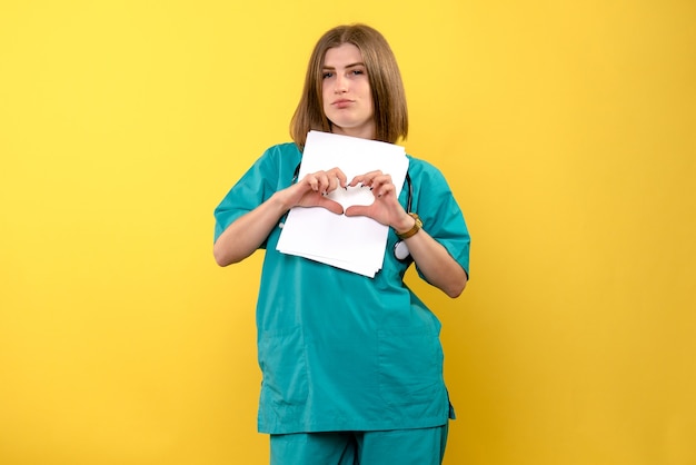 Front view female doctor holding documents on a yellow space