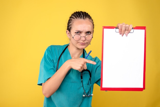 Free photo front view female doctor holding empty medical clipboard, color nurse hospital emotion covid-19 medic