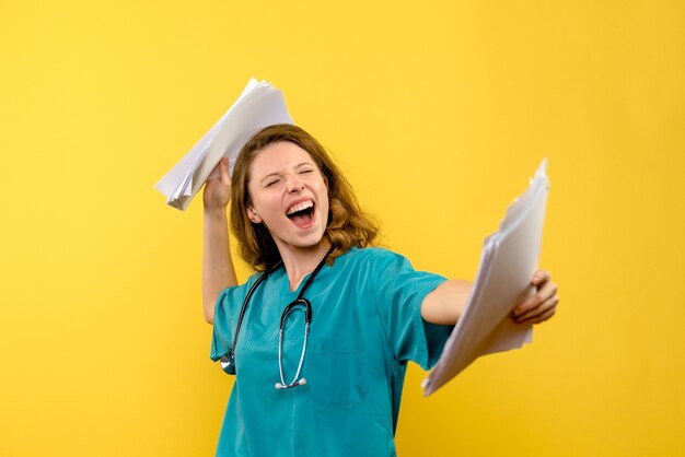 Front view female doctor holding files on a yellow space
