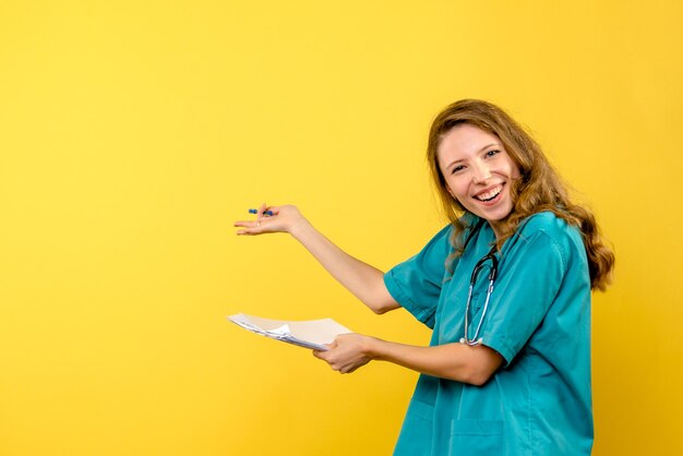 Front view female doctor holding files on yellow space