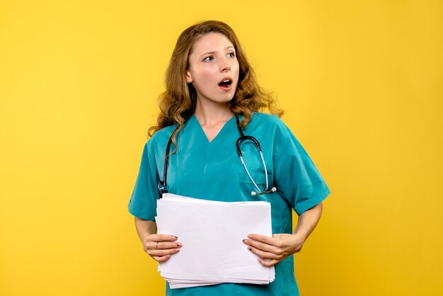 Front view female doctor holding files on yellow space