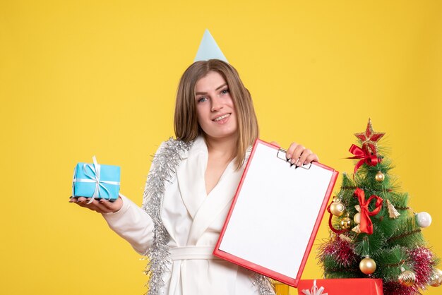 Front view female doctor holding little present and file note