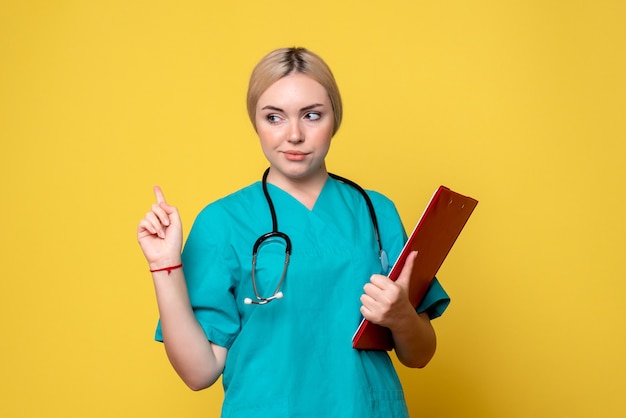 Free photo front view female doctor holding notes, medic ambulance health covid-19 nurse hospital