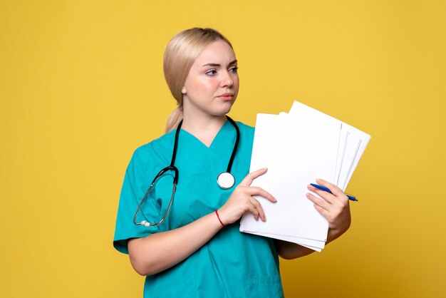 Medico femminile di vista frontale che tiene i documenti, ospedale dell'infermiera covid del virus della medicina di salute del coronavirus