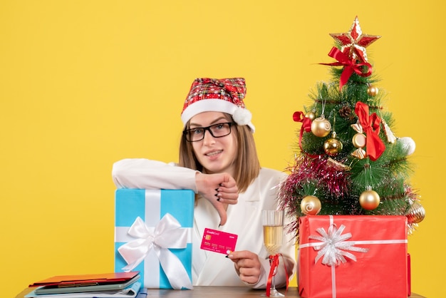 Front view female doctor holding present and bank card