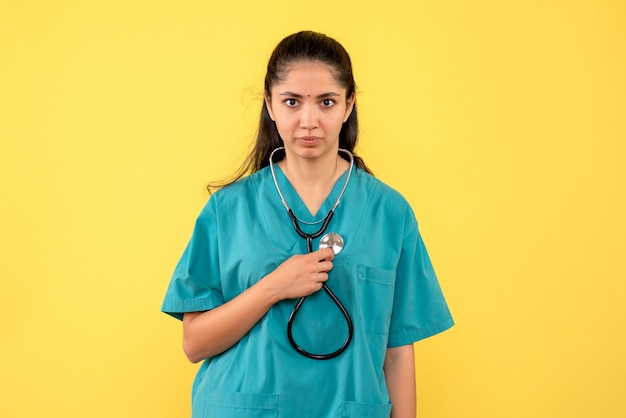 Front view female doctor holding stethoscope posing