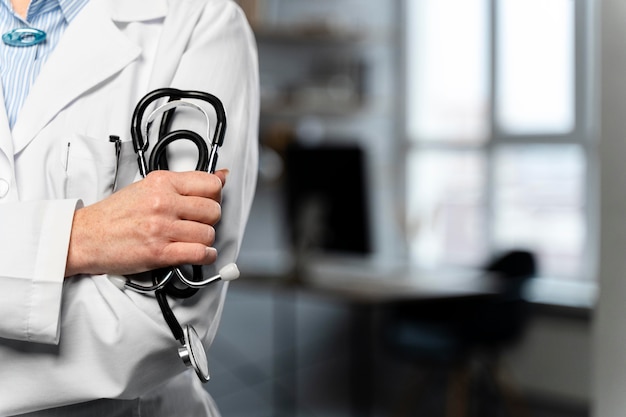 Front view of female doctor holding stethoscope with copy space