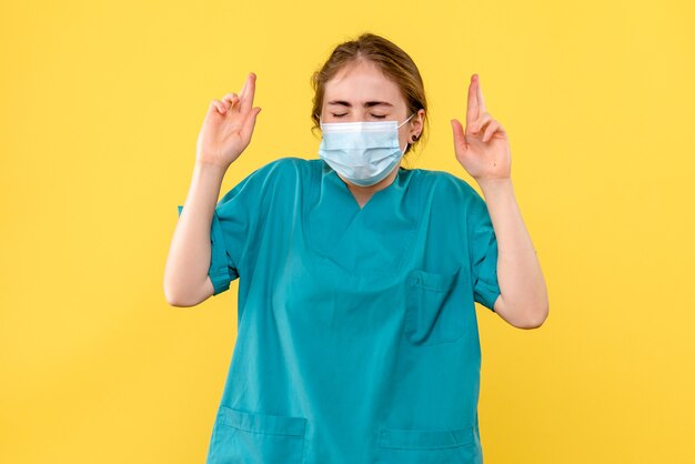 Front view female doctor hoping in mask on yellow background health hospital covid- pandemic