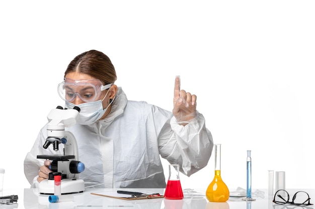 밝은 흰색 배경 의학 Covid- 건강 유행성 바이러스에 현미경을 사용하여 보호 복과 마스크 전면보기 여성 의사