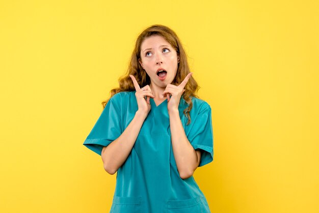 Front view of female doctor just dreaming on yellow wall