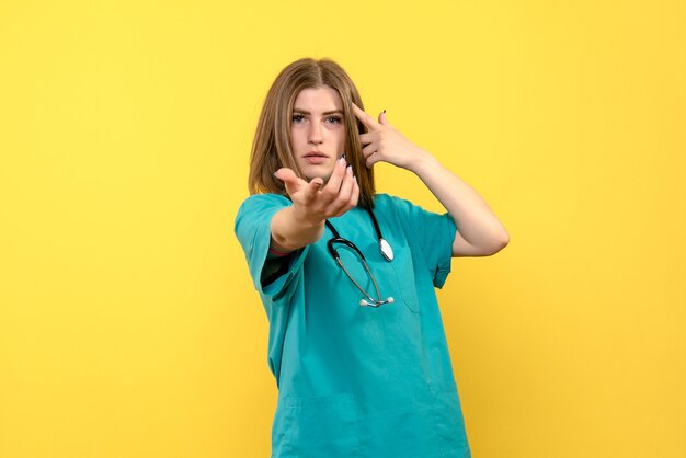 Front view female doctor just standing on yellow space