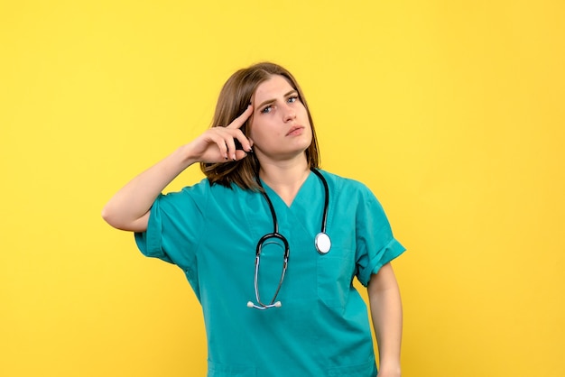 Front view female doctor just standing on yellow space