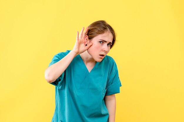 正面図黄色の背景病院の薬の健康感情を聞いている女性医師