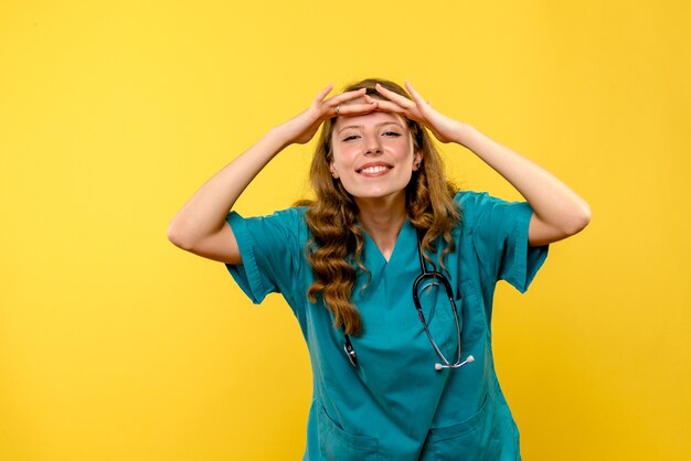 Front view of female doctor looking at distance on yellow wall