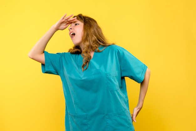 Free photo front view of female doctor looking on yellow wall