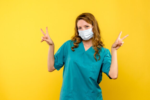 Front view female doctor in mask on yellow space