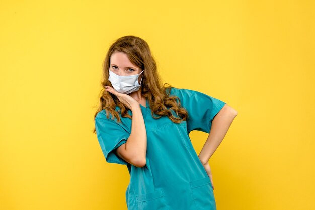 Front view female doctor in mask on yellow space