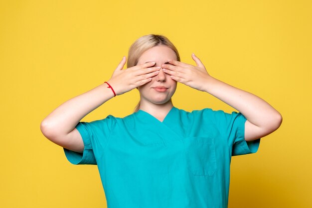 Front view female doctor in medical shirt covering her eyes, medic emotion pandemic covid nurse