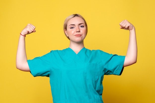 Front view female doctor in medical shirt flexing, medic emotion nurse hospital covid pandemic