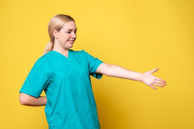 Front view female doctor in medical shirt greeting, nurse medic hospital covid-19 pandemic emotion