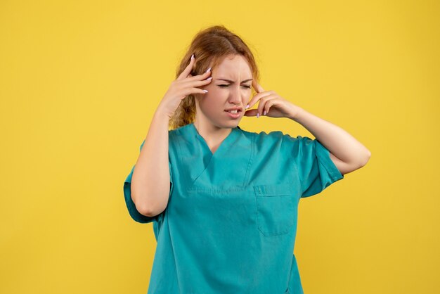 Front view female doctor in medical shirt having headache, health medic covid-19 color hospital nurse