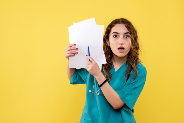 Front view female doctor in medical shirt holding analysis, uniform covid-19 health emotion pandemic virus