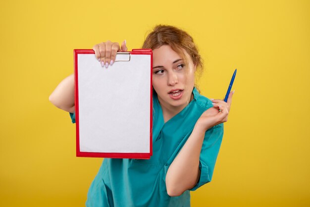 Front view female doctor in medical shirt holding notes, hospital covid-19 health emotion